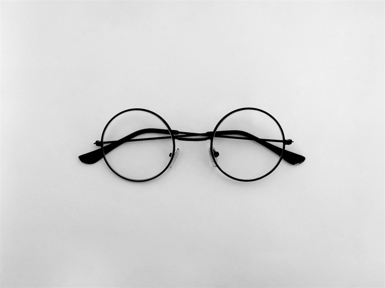 black framed eyeglasses on white surface